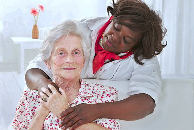 old woman smiling with her caregiver