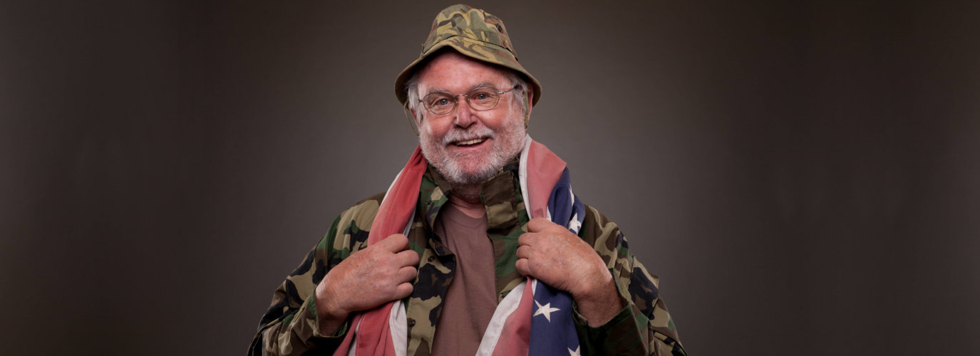 Happy Vietnam Veteran with American flag around his neck