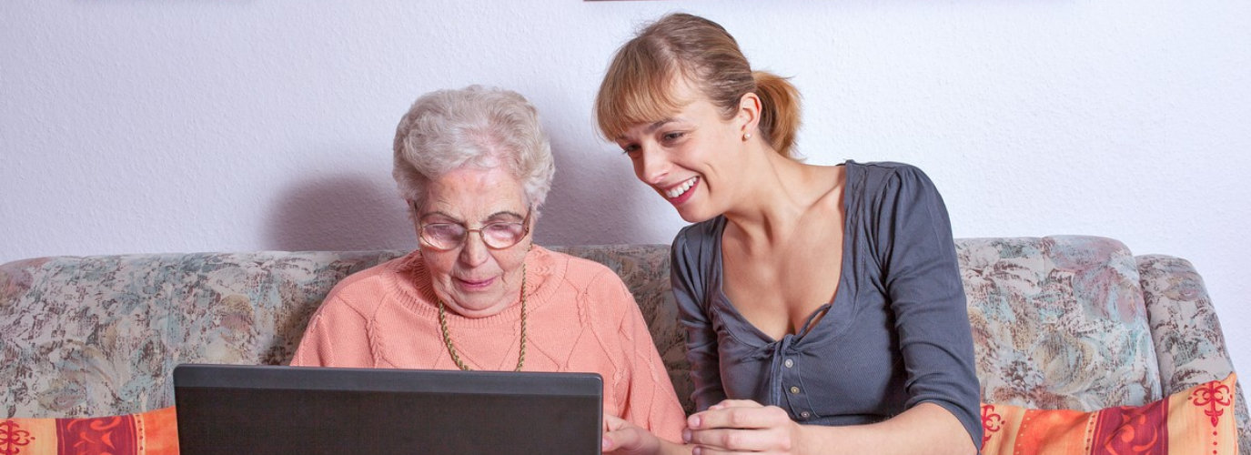 caregiver and senior woman using laptop